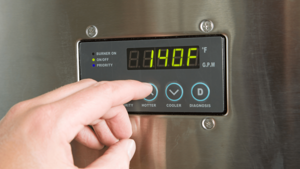 A person is setting temperature on Rheem Tankless Water Heater